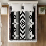 Fika Southwestern Cotton Blend Blanket Throw in Gray, Black and Off-White, on a bed