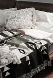 Fika Southwestern Cotton Blend Blanket Throw in Gray, Black and Off-White, draped over a chair