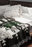 Fika Southwestern Cotton Blend Blanket Throw in Green, Black and Off-White, draped over a chair