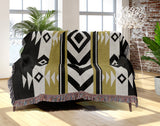 Fika Southwestern Cotton Blend Blanket Throw in Black and Dull Gold, draped over a chair