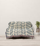 Freda Hand Woven Throw Blanket in Gray and Beige, draped over a sofa