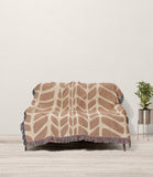 Freda Hand Woven Throw Blanket in Rust and Beige, draped over a sofa