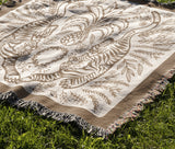 Hero Tibetan Tiger Cotton Blend Blanket Throw in Beige and Off-White, draped over a chair
