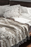 Hinto Southwestern Cotton Blend Blanket Throw in Beige and Off-White, draped over a chair