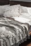 Hinto Southwestern Cotton Blend Blanket Throw in Gray and Off-White, draped over a chair
