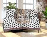 Inky Leopard Cotton Blend Blanket Throw in Beige, Gray and Off-White, draped over a chair
