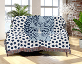 Inky Leopard Cotton Blend Blanket Throw in Blue and Off-White, draped over a chair