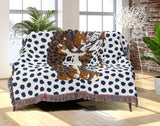 Inky Leopard Cotton Blend Blanket Throw in Blue, Burnt Orange and Off-White, draped over a chair