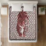 Inky Leopard Cotton Blend Blanket Throw in Pink, Purple and Off-White, on a bed