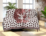 Inky Leopard Cotton Blend Blanket Throw in Pink, Purple and Off-White, draped over a chair