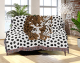 Inky Leopard Cotton Blend Blanket Throw in Black, Rust Brown and Off-White, draped over a chair