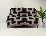 Jansen Cotton Blend Blanket Throw in Black, draped over a chair