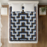 Jansen Cotton Blend Blanket Throw in Navy Blue, draped over a chair