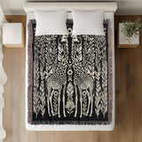 Josu Giraffe Cotton Blend Blanket Throw in Black and Off-White, draped over a chair