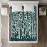 Josu Giraffe Cotton Blend Blanket Throw in Teal and Off-White, on a bed