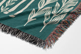 Josu Giraffe Cotton Blend Blanket Throw in Teal and Off-White, draped over a chair