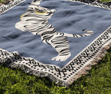 Kat Tiger Cotton Blend Blanket Throw in Light Blue and Off-White, draped over a chair