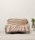 Konga Hand Woven Throw Blanket in Rust and Beige, draped over a sofa