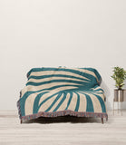 Konga Hand Woven Throw Blanket in Teal and Beige, draped over a sofa