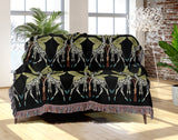 Kossy Giraffe Cotton Blend Blanket Throw in Black and Green, draped over a chair