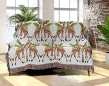 Kossy Giraffe Cotton Blend Blanket Throw in Green, Burnt Orange and Off-White, draped over a chair