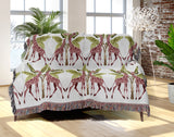 Kossy Giraffe Cotton Blend Blanket Throw in Pink, Green and Off-White, draped over a chair