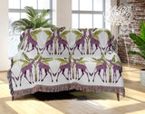 Kossy Giraffe Cotton Blend Blanket Throw in Purple, Green and Off-White, draped over a chair