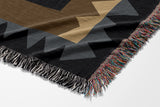 Kotu Snake Cotton Blend Blanket Throw in Black, Brown and Blue, draped over a chair