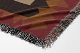 Kotu Snake Cotton Blend Blanket Throw in Red, Brown, Beige and Gray, draped over a chair