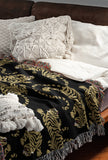 Leonard Tiger Cotton Blend Blanket Throw in Black and Off-White, draped over a chair