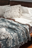 Leonard Tiger Cotton Blend Blanket Throw in Blue Gray and Off-White, draped over a chair