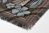 Lim Elephant Cotton Blend Blanket Throw in Beige, Blue and Off-White, draped over a chair