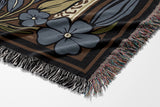 Lim Elephant Cotton Blend Blanket Throw in Black, Green and Yellow, draped over a chair