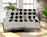 Lissa Dots Abstract Cotton Blend Blanket Throw in Beige, Black and Off-White, draped over a chair
