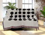 Lissa Dots Abstract Cotton Blend Blanket Throw in Black and Off-White, draped over a chair