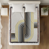 Merna Cotton Blend Blanket Throw in Black, on a bed