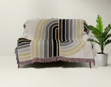 Merna Cotton Blend Blanket Throw in Black, draped over a chair