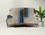 Merna Cotton Blend Blanket Throw in Blue, draped over a chair