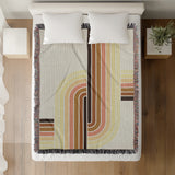 Merna Cotton Blend Blanket Throw in Orange, on a bed