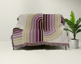 Merna Cotton Blend Blanket Throw in Purple, draped over a chair