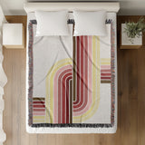 Merna Cotton Blend Blanket Throw in Red, on a bed