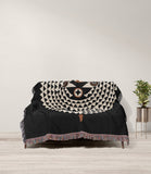 Mossi African Mask 100% Cotton Blanket in Black and Beige, draped over a sofa