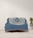 Mossi African Mask 100% Cotton Blanket in Blue and Beige, draped over a sofa