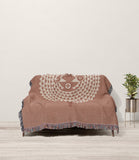 Mossi African Mask 100% Cotton Blanket in Rust and Beige, draped over a sofa