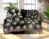 Nivo Peacock Cotton Blend Blanket Throw in Black, draped over a chair