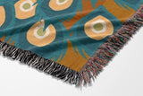 Nivo Peacock Cotton Blend Blanket Throw in Burnt Orange, on a bed