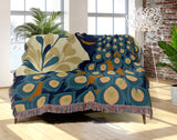Nivo Peacock Cotton Blend Blanket Throw in Dark Turquoise, draped over a chair