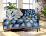 Nivo Peacock Cotton Blend Blanket Throw in Light Blue, draped over a chair