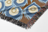 Nivo Peacock Cotton Blend Blanket Throw in Rust Brown, on a bed