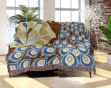 Nivo Peacock Cotton Blend Blanket Throw in Rust Brown, draped over a chair